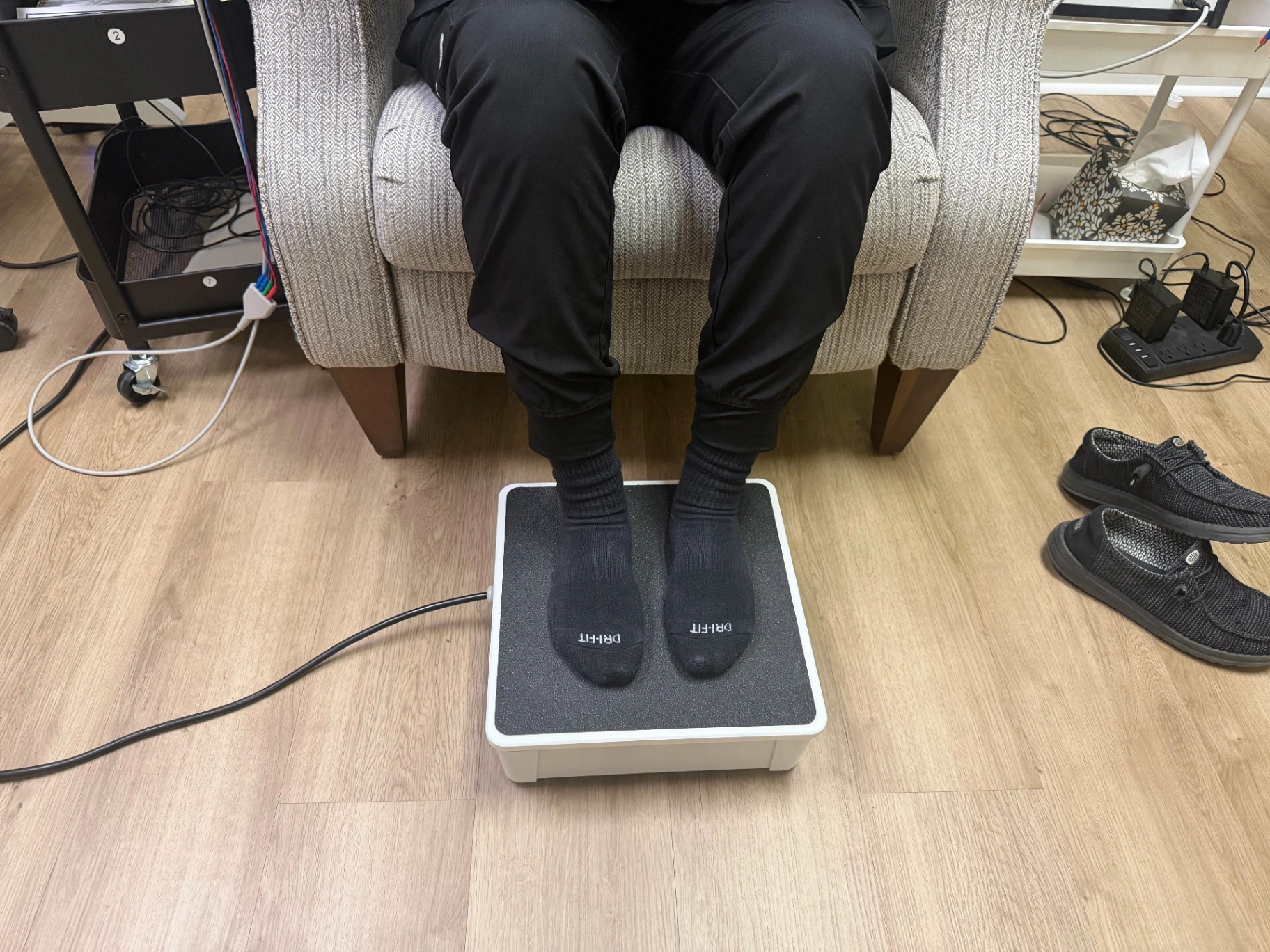 Patient using the Nerve Plate for neuropathy stimulation therapy at Faulkenberry Chiropractic in Little Rock