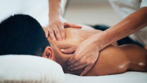 Massage therapist providing therapeutic back massage to support immune health, stress relief, muscle recovery, and overall wellness.